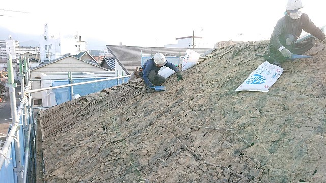 屋根の葺き土の掃除している写真