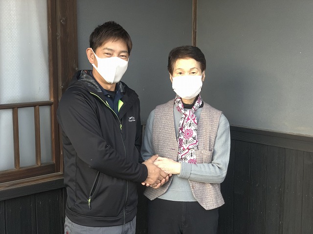 マスクをして握手している２人